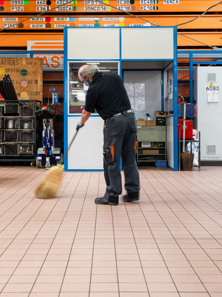Agent d’entretien balayant atelier - Nettoyage sol industriel - Reportage photographie en usine - Studio photo Loire-Atlantique