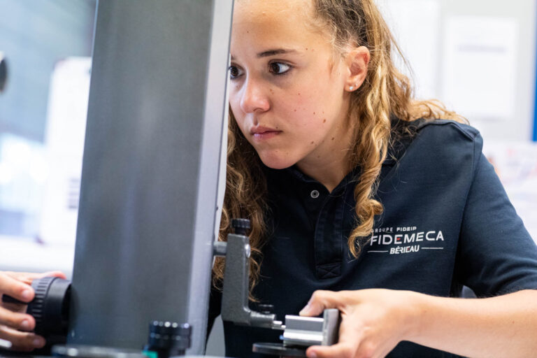 Technicienne effectuant un contrôle de précision - Mesure dimensionnelle sur pièce mécanique - Photographie industrielle en Vendée - Créateur de contenu Nantes