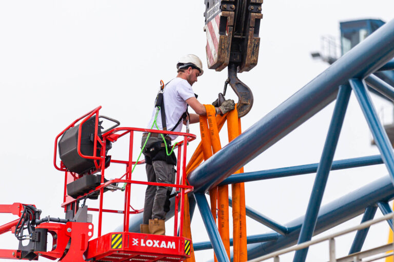 Ouvrier fixant une élingue sur la flèche - Intervention sur grue métallique - Reportage technique de levage - Brunet-Monié