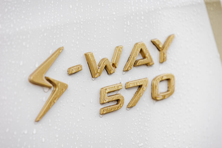 Logo doré S-WAY 570 sur carrosserie - Gouttes de pluie sur peinture blanche - Photo publicitaire de camion - photographe nantes