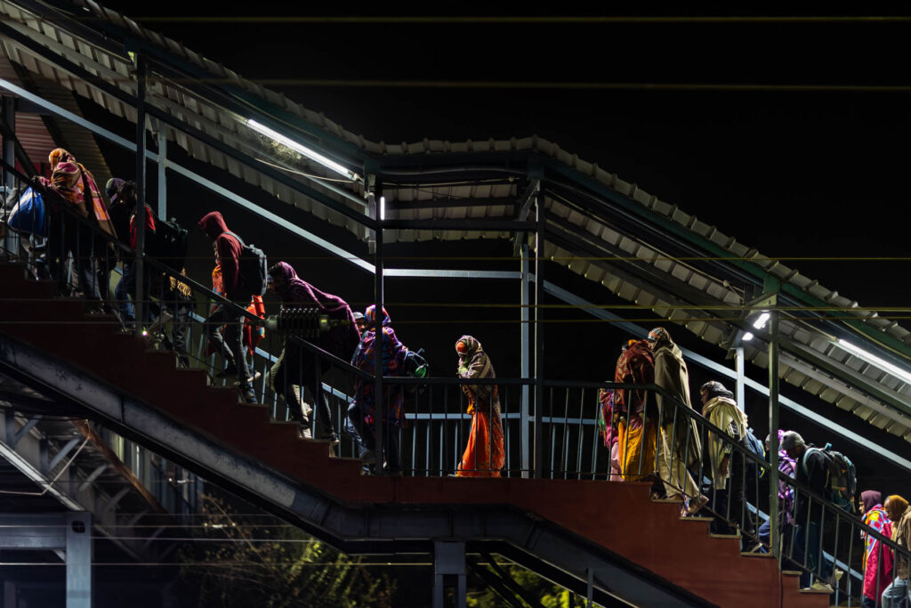Voyageurs en sari montant passerelle gare - Escalier métallique de nuit Inde - Le Rajasthan en Mouvement - studio photo Loire-Atlantique