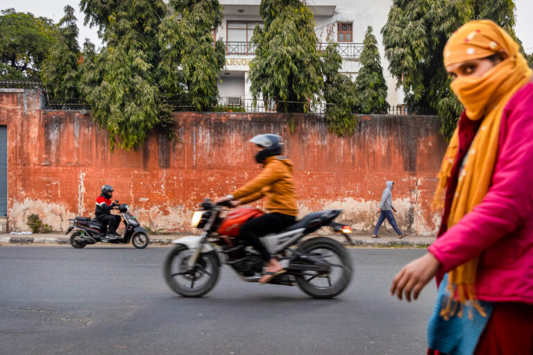 Motos et passants sur artère indienne - Mur orange typique Rajasthan - Scène urbaine contemporaine - studio photo Loire-Atlantique