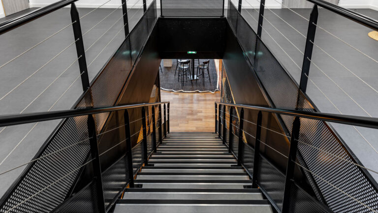 Escalier intérieur structure métal - Vue plongeante cage d’escalier moderne - Photographie d’architecture sportive - photographe nantes