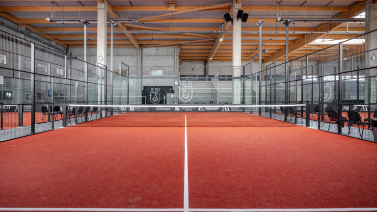 Terrain de padel intérieur - Filet central court rouge - Photoreportage infrastructure sportive - Agence photo à Nantes