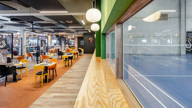 Restaurant vue terrain - Baie vitrée sur court indoor - reportage d’architecture - photographe de club de sport
