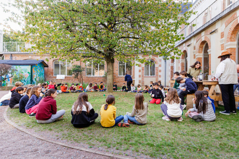 Grand cercle d’enfants assis dans la cour - Moment collectif en plein air - Séjour immersif enfants - photographe nantes
