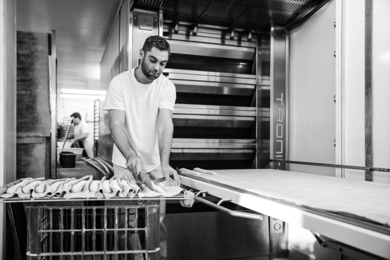 Préparation de baguettes crues - Four à pains en arrière-plan - Photoreportage en boulangerie - photographe nantes