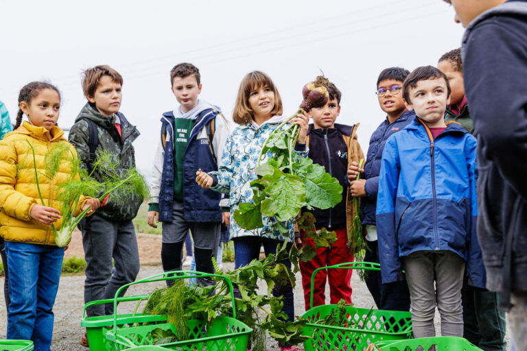 Groupe d’enfants montrant légumes récoltés - Scène pédagogique en ferme - Reportage publicitaire - Agence photo à Nantes