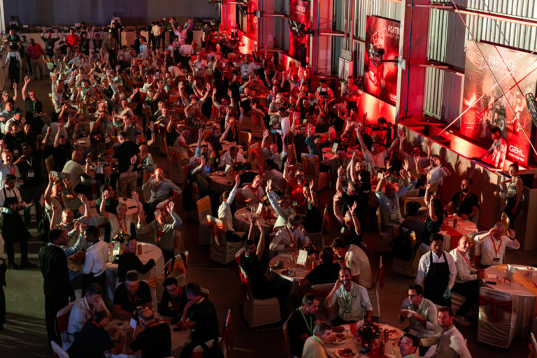 Salle de gala animée - Invités levant les bras lors de la soirée - Reportage événementiel corporate - Agence Brunet-Monié