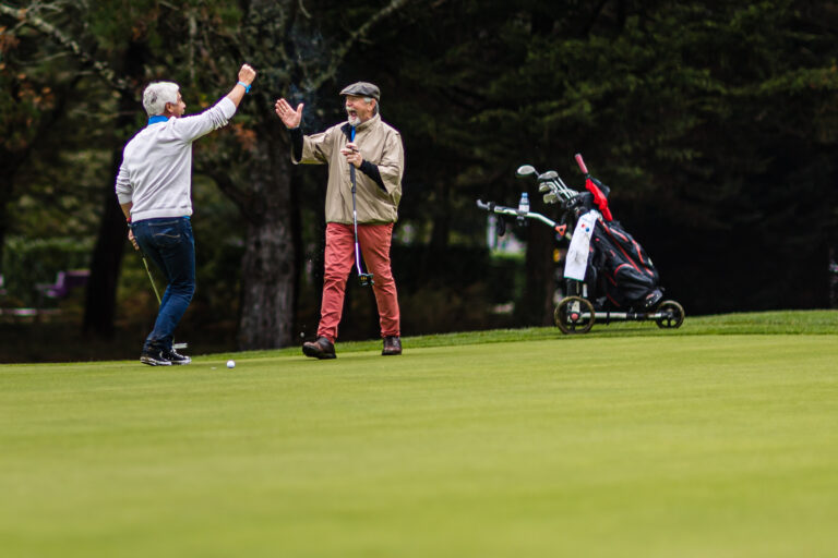 Joueurs célébrant un putt réussi - Poignée de main levée dynamique - Photoreportage golf humain - photographe nantes