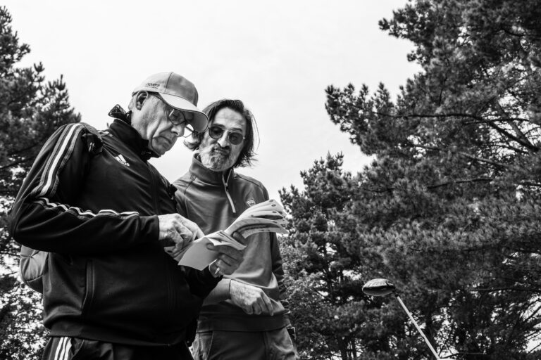 Consultation fiche de score - Coéquipiers concentrés sous les arbres - Reportage événementiel sportif - Agence photo à Nantes