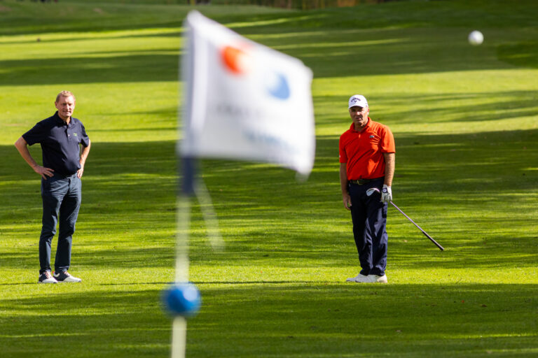 Golfeurs observant trajectoire balle - Drapeau flouté premier plan - Photoreportage compétition golf - créateur de contenu nantes
