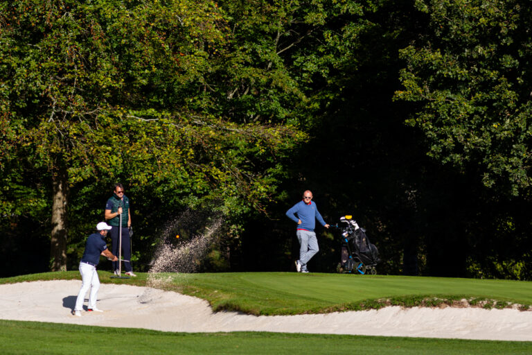 Coup de sable sur green - Joueurs observant au bord du fairway - Reportage visuel golfique - Agence Brunet-Monié