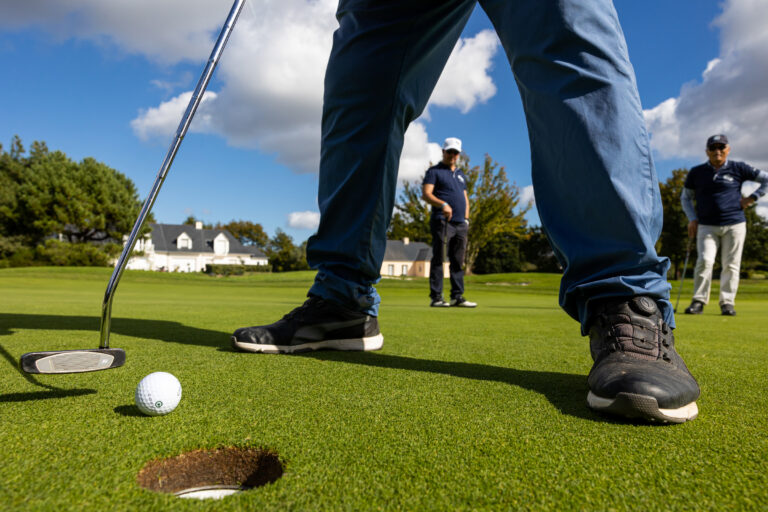 Balle près du trou de golf - Mains prêtes pour putter - Reportage sportif en plein air - Agence photo à Nantes