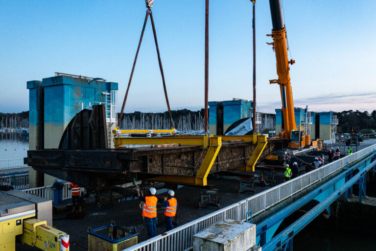 Levage de pièce métallique au crépuscule - Équipe chantier en pleine coordination - Photographier l’excellence technique - Agence Brunet-Monié