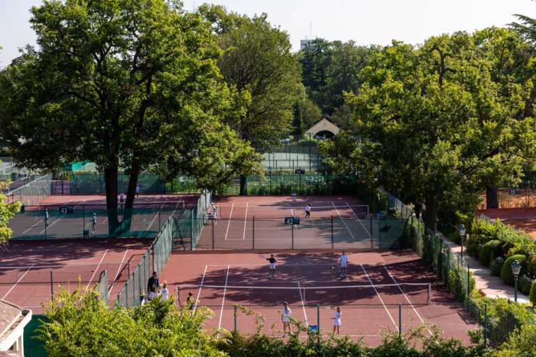 Vue aérienne courts de tennis rouges - Activité sportive en pleine nature - Reportage sport chic parisien - Créateur de contenu Nantes