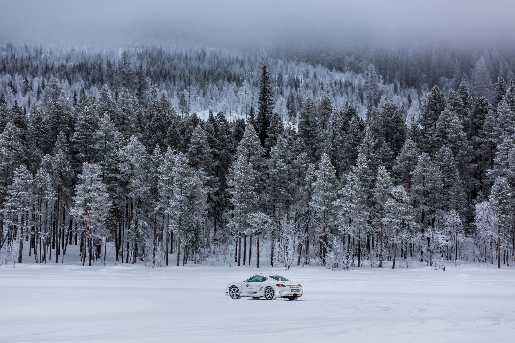 Porsche cayman sur lac gelé - Forêt enneigée Laponie en arrière-plan - Pilotage sur glace - studio photo Loire-Atlantique