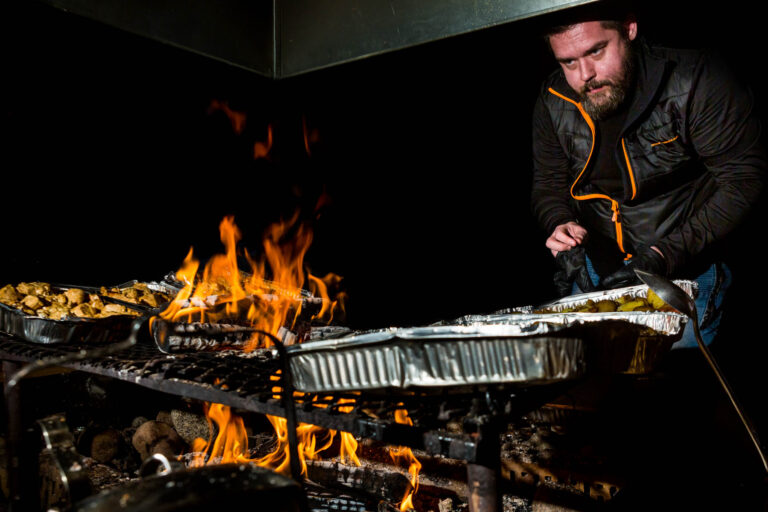 Cuisson grillades sur feu de bois - Chef préparant repas convivial - Reportage événementiel Laponie - Brunet-Monié