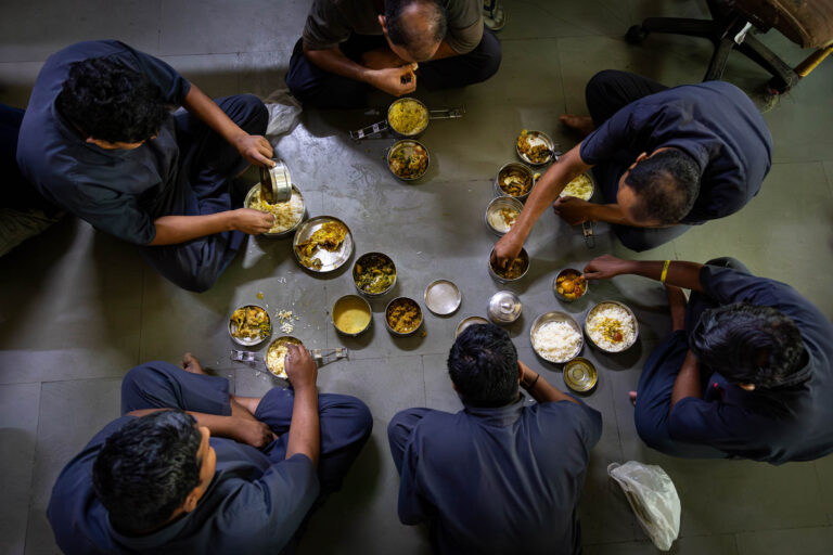 Ouvriers indiens partageant repas - Pause déjeuner au sol usine - Reportage documentaire quotidien - Agence photo à Nantes