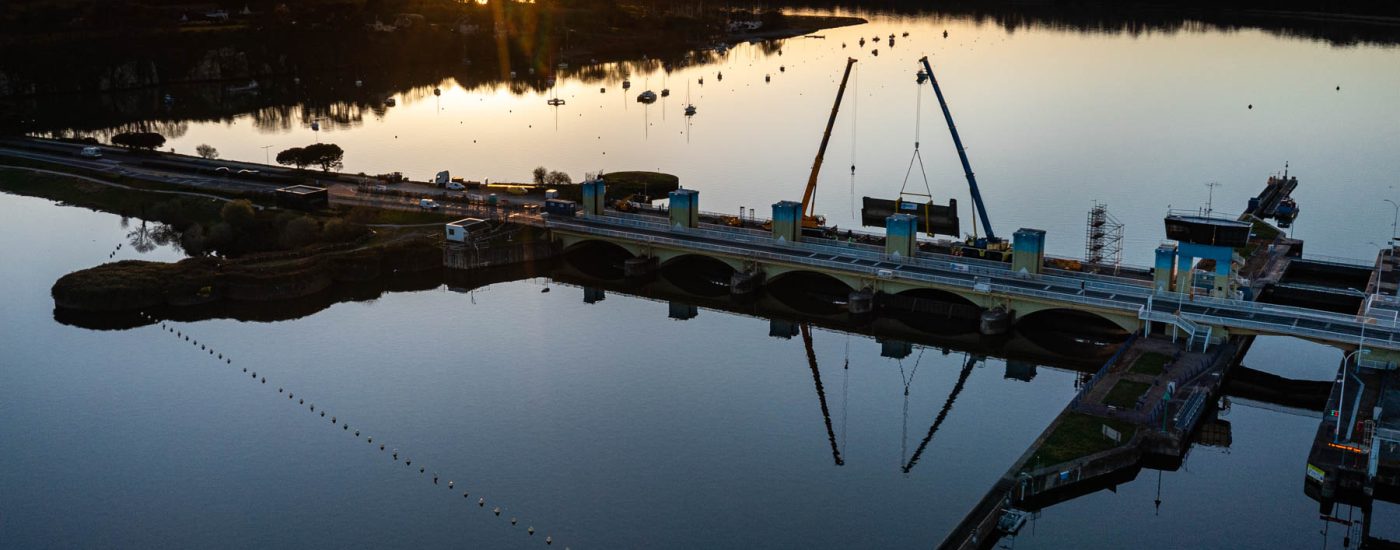 Vue aérienne du barrage d’Arzal au lever du jour - Grues en action sur vanne hydraulique - Photoreportage infrastructure industrielle - photographe nantes