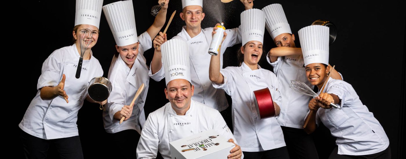 Groupe d’étudiants posant avec ustensiles - Paul Hing - Équipe dynamique et créative - Célébration du Salon du Chocolat - Photographe Nantes